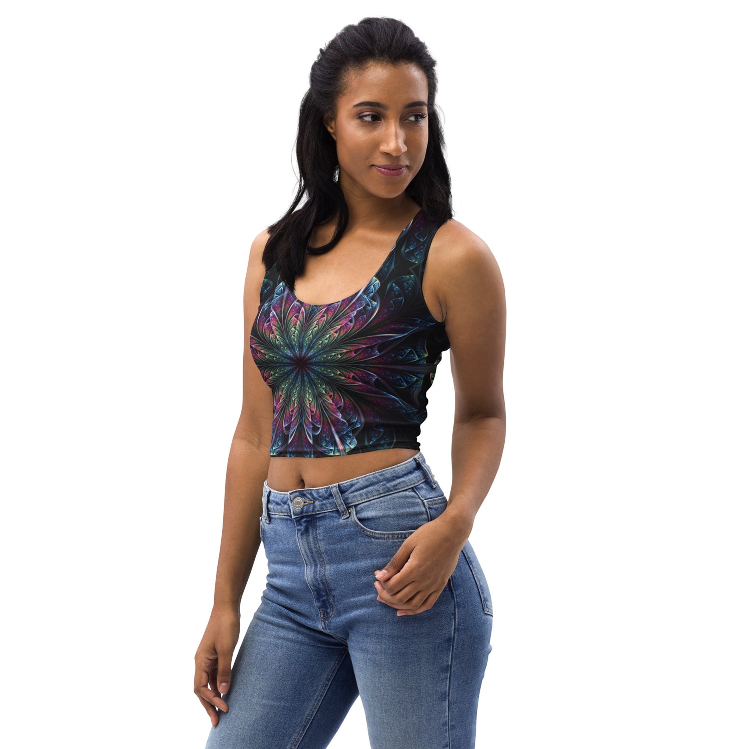 Woman wearing a black crop top with a psychedelic mandala design in multicolor, paired with blue jeans.